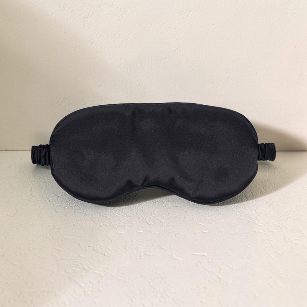 Black luxury satin mask by Bare Intentions, with smooth, shiny fabric and elegant design perfect for skincare or fashion wear.