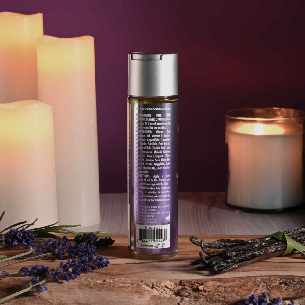 Bare Intentions lavender and vanilla massage oil bottle with a pump dispenser, set on a wooden surface.